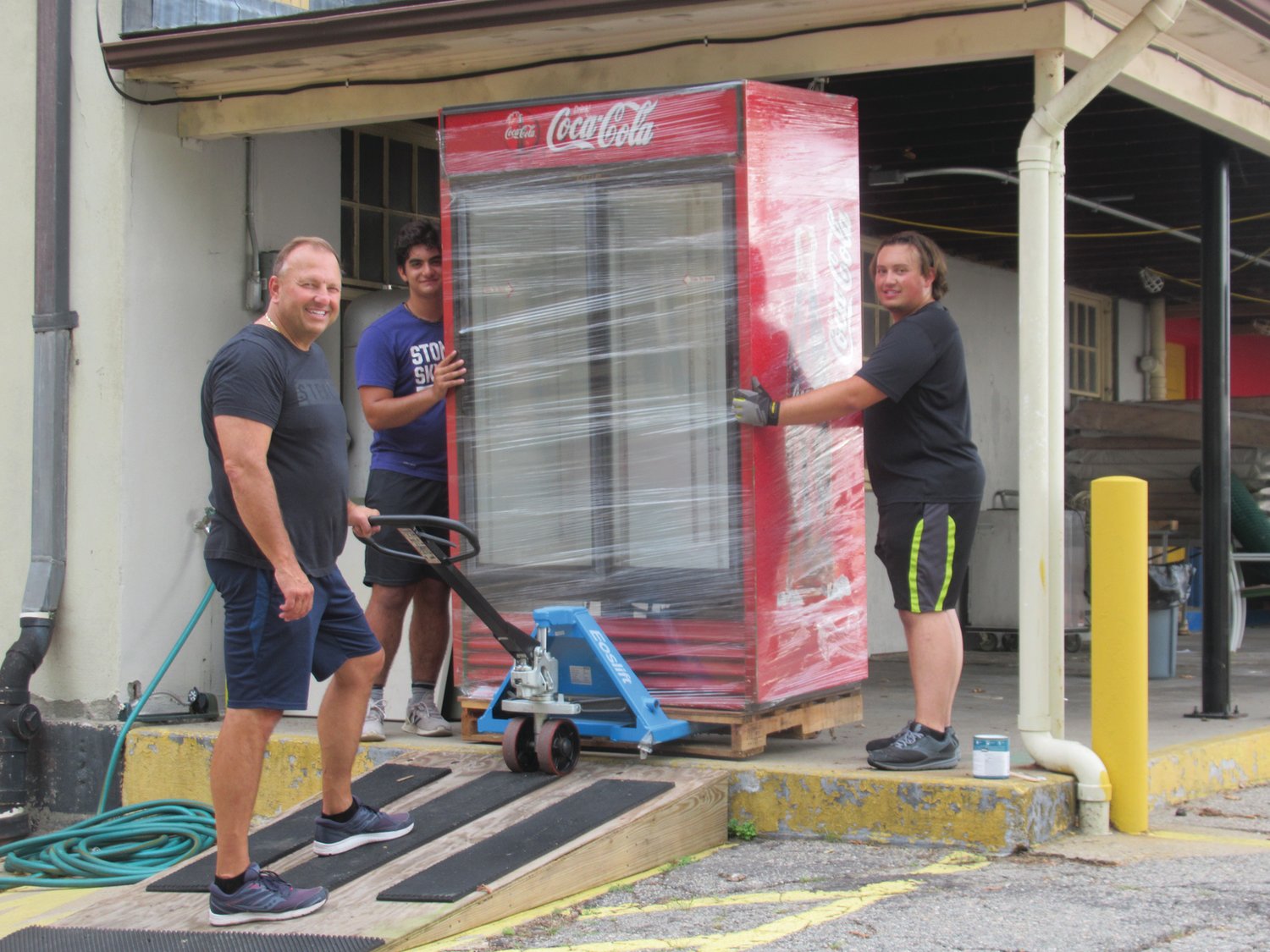 DAN’S DUTY: Dan Parrillo (center) and his son Mitchell (right) and Julius DiSanto are taking a huge cooler out of storage that will be used for food items during this weekend’s St. Rocco’s Feast and Festival that opens Thursday evening in Johnston.